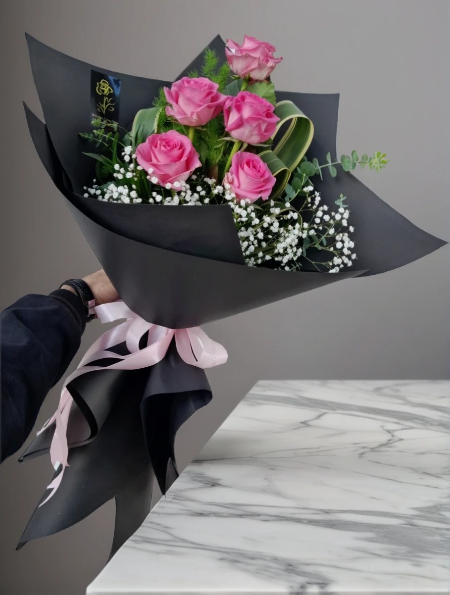**"دسته‌گل رز قرمز لوکس 5 شاخه با کاور مشکی و تزئین برگ و ژپسوفیلا، مناسب برای هدیه و مناسبت‌های خاص در ارومیه. خرید آنلاین گل با تحویل سریع از بهترین گلفروشی ارومیه."**