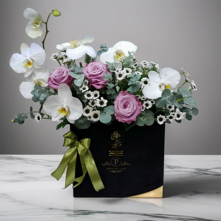 باکس گل مجلسی مشکی با ارکیده سفید، رز یاسی، کرتنزیا سفید و اکالیپتوس - تزئینات لاکچری هدیه در ارومیه